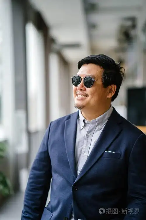 一位中年中国亚裔男子(新加坡人)的肖像,穿着智能休闲,站在城市里.