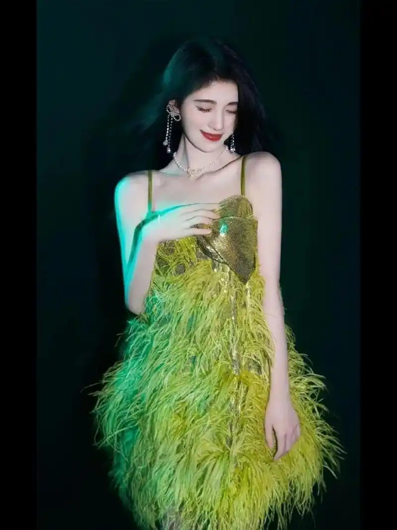 鞠婧祎的气质真的是绝了,穿着一条绿色的羽毛吊带连衣裙,清新浪漫,优