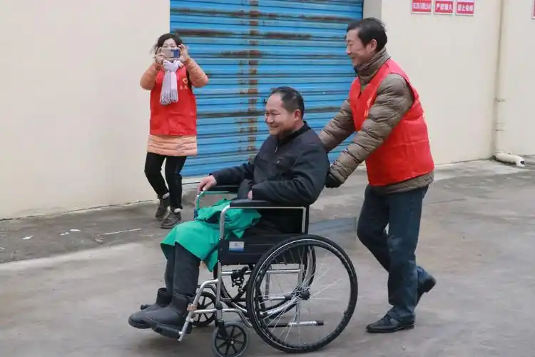 机关专职副书记陈峰帮残疾人推轮椅,感受到残疾人身体残疾给生活上
