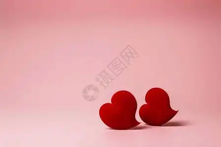两颗红色天鹅绒心在粉红色背景上柔和地聚焦背景与情人节或婚图片素材