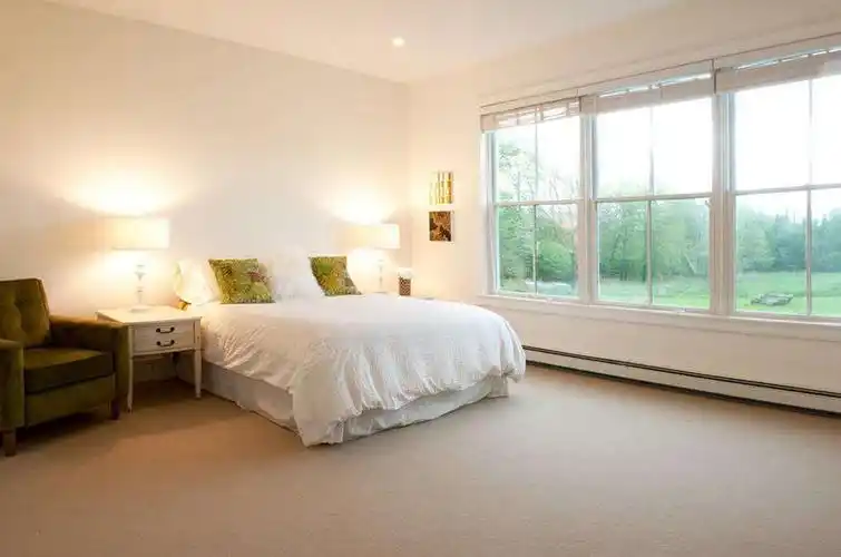 这是长方形卧室的装修效果图,墙面采用了灰白相间的壁纸,线条感十足