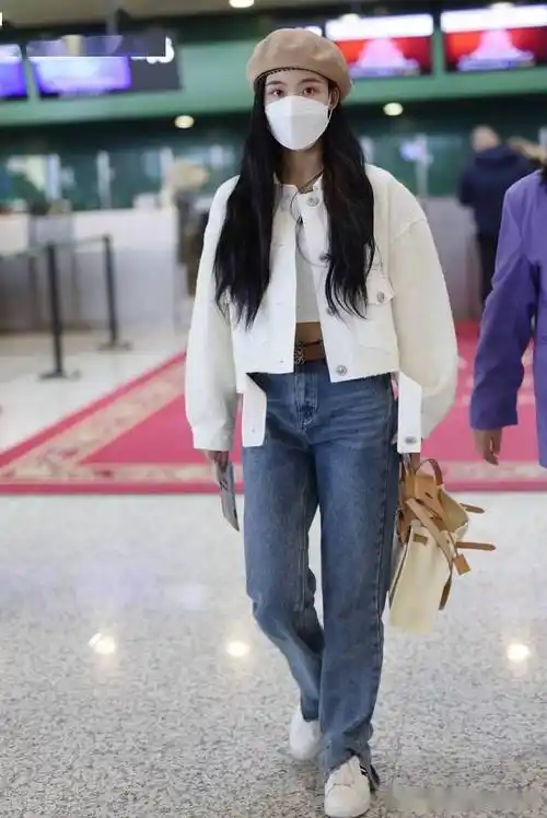 2021年10月21日,孙茵街拍,头戴帽子口罩遮面身穿白色外套搭配牛仔裤