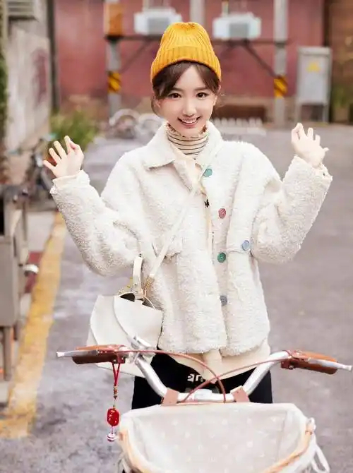 毛晓彤春日胡同随拍,一身米色毛绒外套搭配小黄帽,娇俏又可爱
