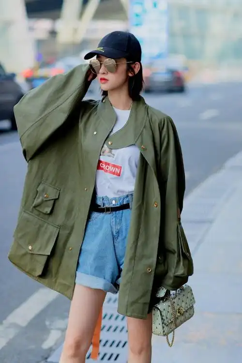唐艺昕身着白色t恤牛仔短裤外搭军绿色廓形外套,休闲运动风酷美兼备.
