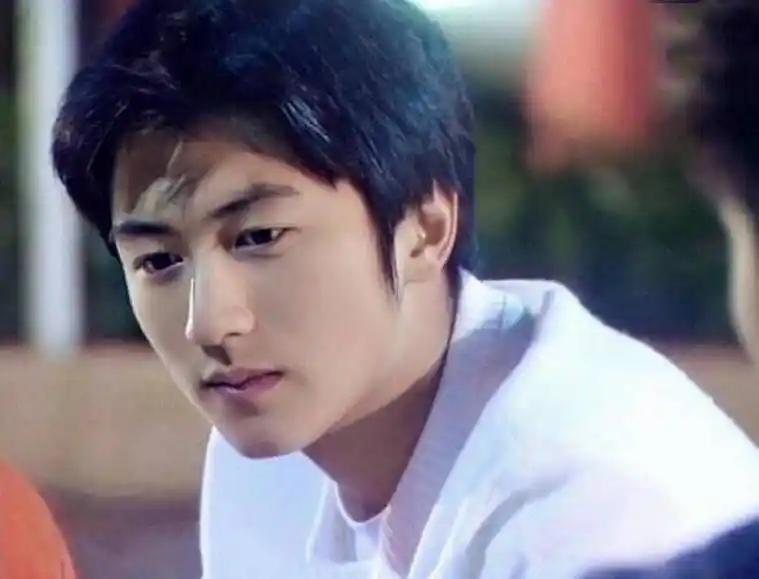 少年谢霆锋的打扮很简单,身穿白色上衣,剪着清爽的短发,额前刘海翘