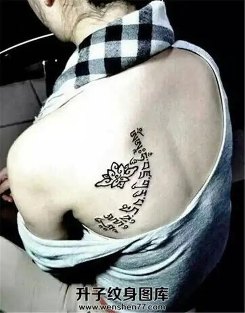 女性后肩背部的弧线形梵文纹身