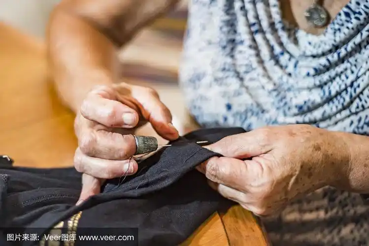 老妇人用手缝衣服