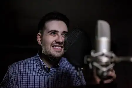 男配音演员在配音室表演和微笑图片素材