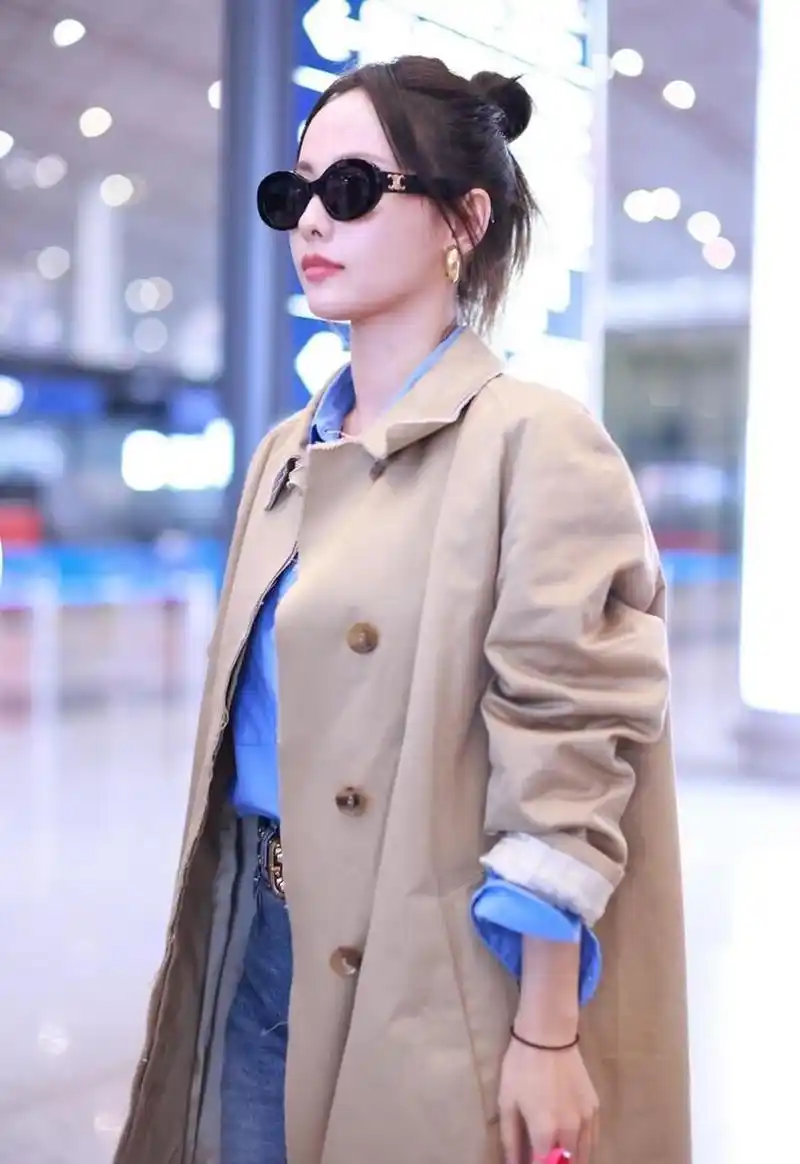 张嘉倪机场街拍,卡其色风衣内搭蓝色衬衫,开叉牛仔裤,中性帅气!