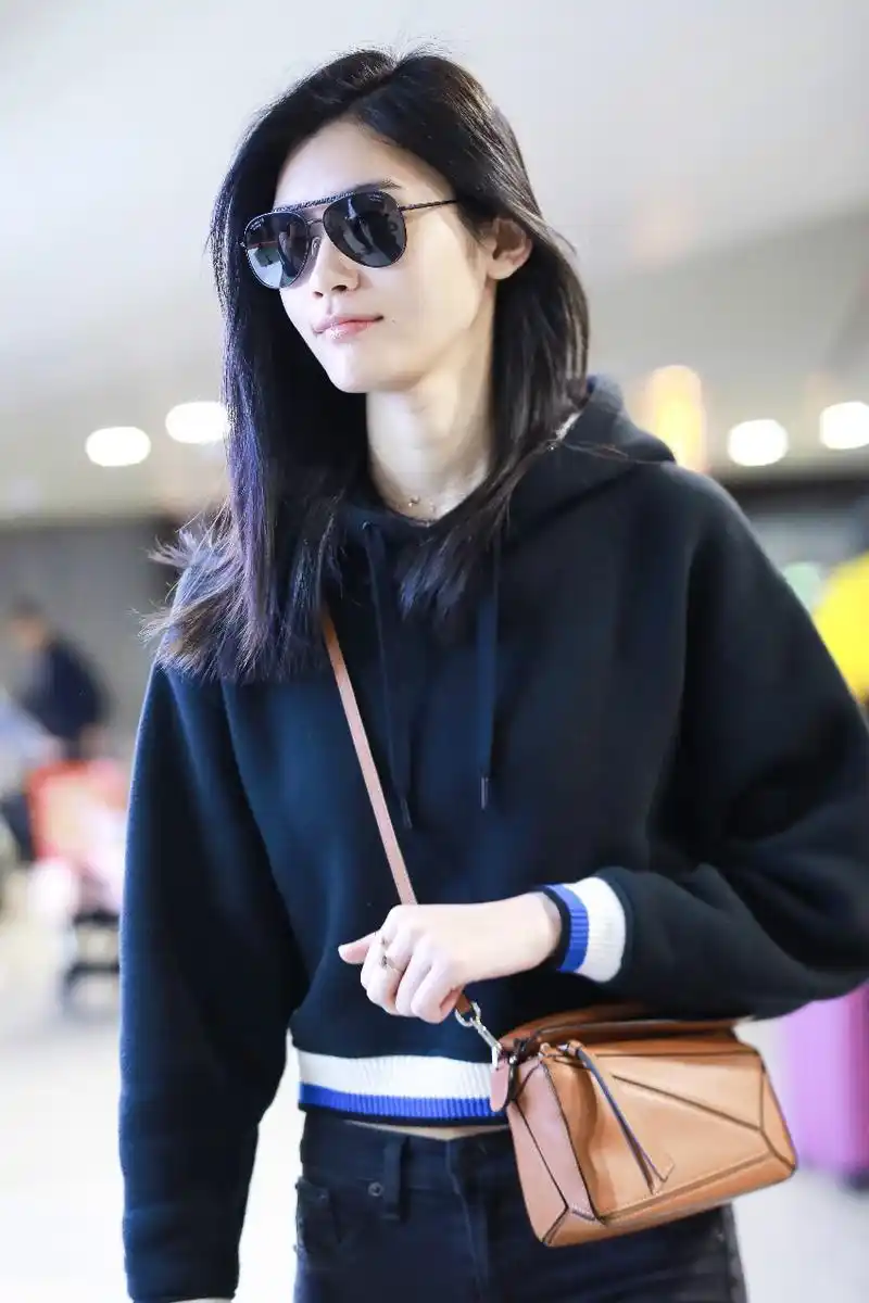 奚梦瑶戴墨镜穿黑色卫衣搭配黑色裤子现身机场,皮肤白皙笑容灿烂