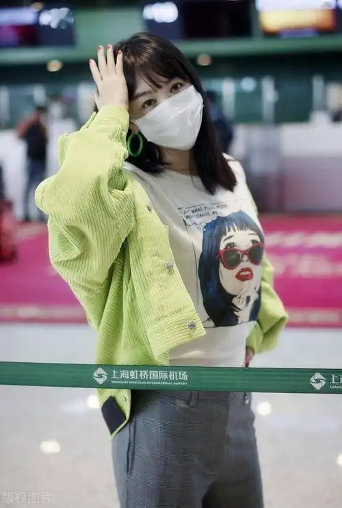李菲儿穿嫩绿色上衣搭灰色休闲裤打卡机场拍照姿势俏皮又可爱