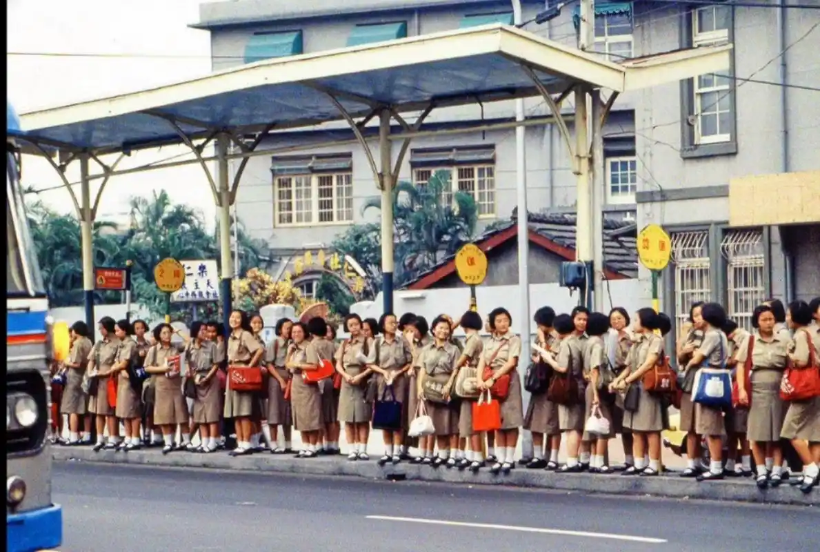 八十年代,台湾街头,正在等待校车的学生,他们穿着统一制服,校服很是
