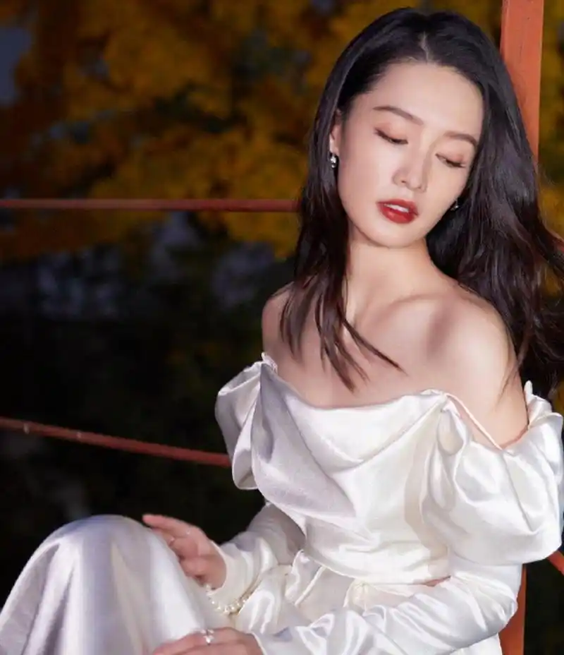 李沁一袭白色抹胸裙,肤白貌美气质佳.