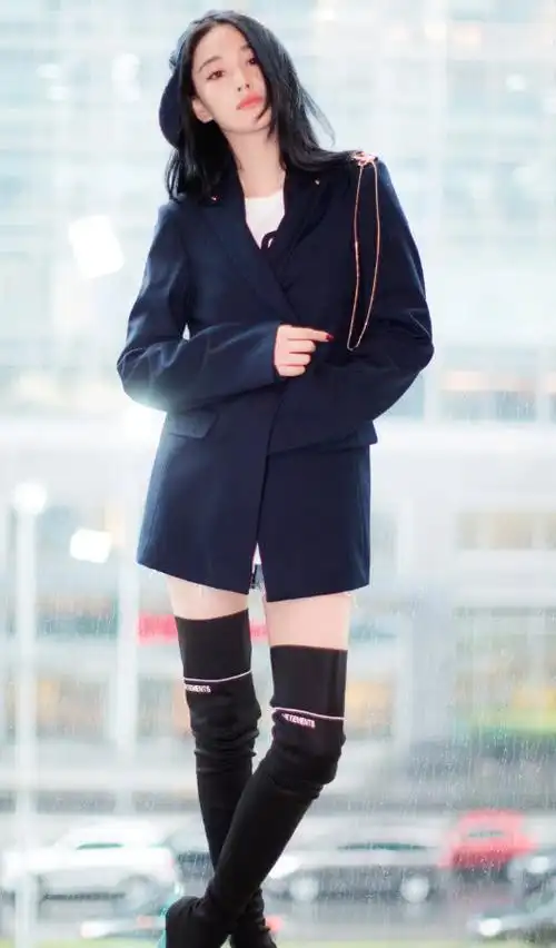 张馨予身穿一件白色t恤,在外还穿了一件黑色西装和一双黑过膝长靴.