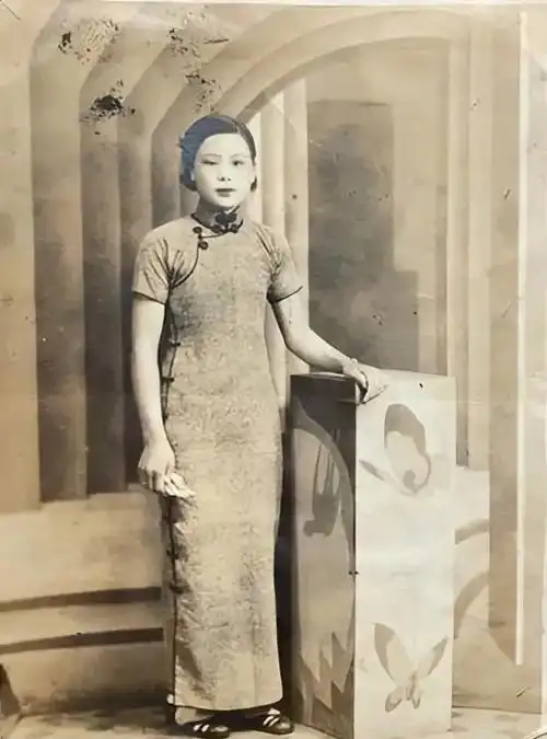 民国时期,一位富家太太靓丽留影,照片中她身着一件合身的旗袍,线条