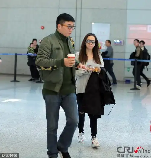 张靓颖素颜节大口喝咖啡 老公冯轲推行李变苦力
