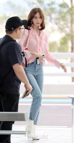 林允儿穿粉色衬衫搭配牛仔裤现身机场,面带微笑挥手打招呼显亲和