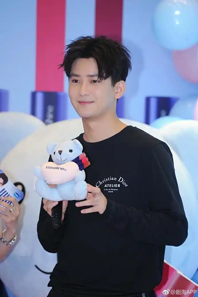 熊梓淇穿黑色卫衣搭配黑色运动裤亮相活动,面带微笑,帅气十足.