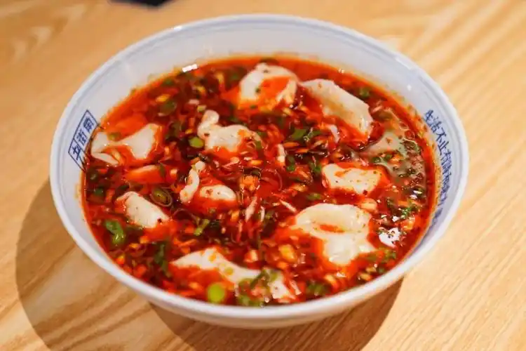 上桌就让人垂涎三尺:搭配独特的酸菜馅儿和辣油,一个个敦实的汤水饺