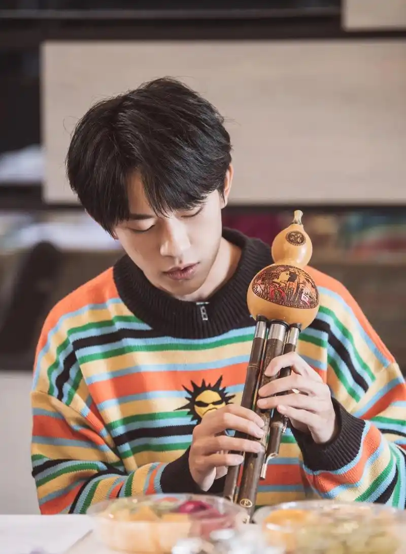 易烊千玺着彩色条纹毛衣青春活力吹葫芦丝撸猫闲适放松