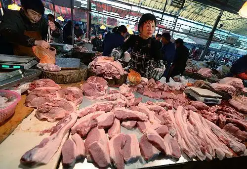 江西南昌市东湖区一家农贸市场的摊主在叫卖猪肉