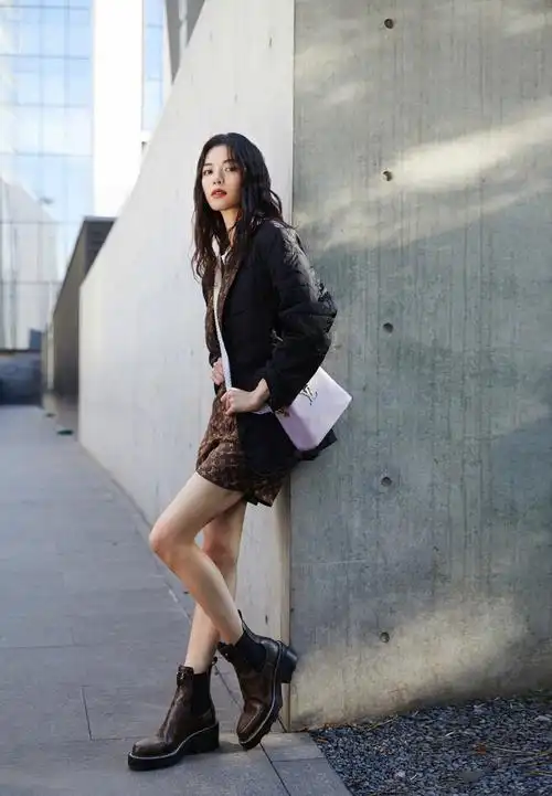 钟楚曦身着黑色外套和短裤,披肩长发知性气质