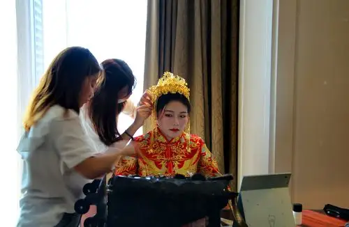 化妆师在为新娘带凤冠霞帔.