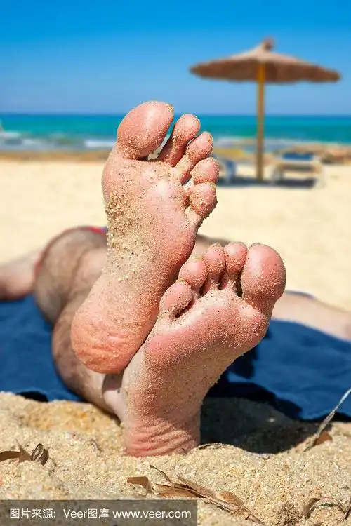 男人的脚在海滩上