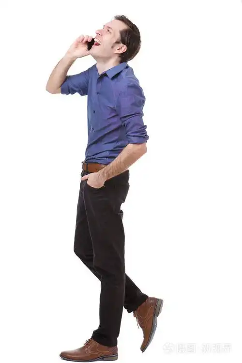 英俊男子的全长侧面肖像行走和交谈的手机