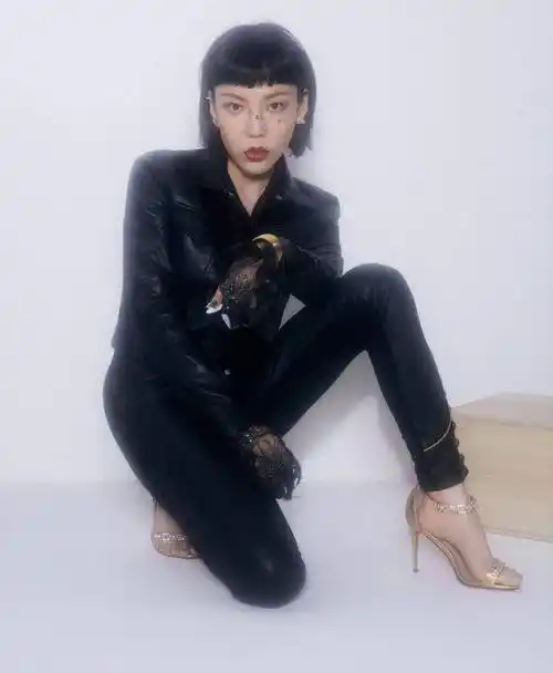 下半身再搭配了一条黑色长皮裤的吴莫愁还踩着一双金色的细高跟,化了