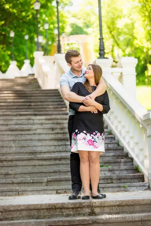 夫妇在公园的石台阶上拥抱的爱情
