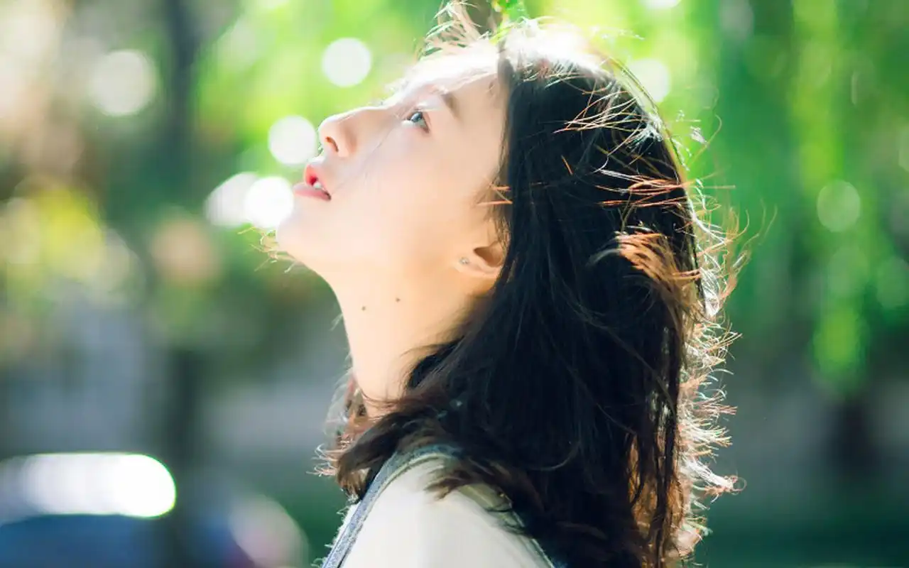 图片中的女孩一头长发,清新阳光,身穿白色毛衣,皮肤白皙,十分养眼