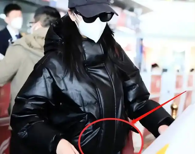 迪丽热巴怀孕风波后,亲自推行李箱赶机场,衣服臃肿侧面大肚明显_迪利