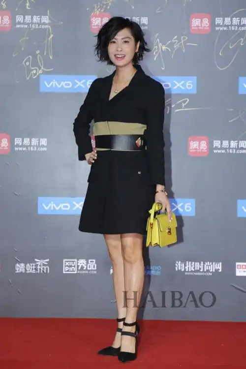 朱茵——一身黑色束腰西服短裙,搭配黑色尖高跟,手提亮黄色包包点缀