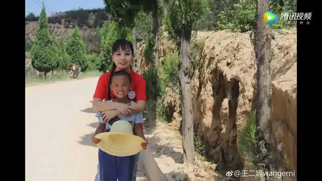 从照片上我们看到,王二妮亲昵的抱着这个小男孩,还一起打闹,关系看