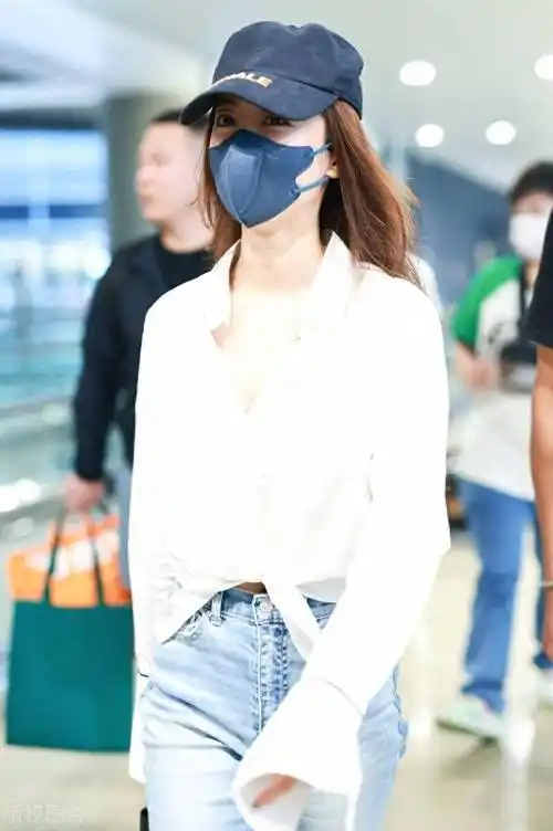 街拍:蔡依林白衬衫 牛仔裤 运动鞋 棒球帽 黑色手提包简单时尚_上海