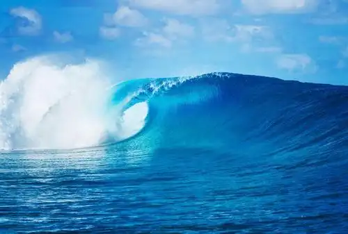 蓝天白云背景下翻滚的蓝色海浪