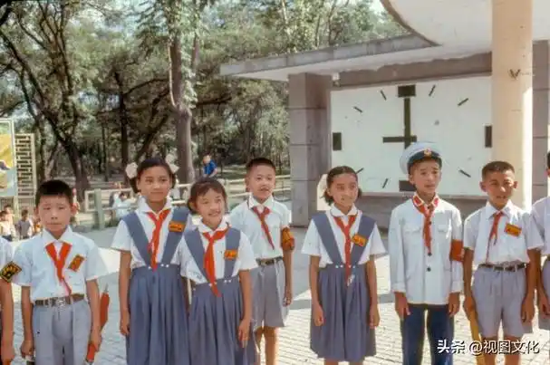 公园里游玩的小学生,除了戴军帽的孩子外,男生女生都穿着统一的校服