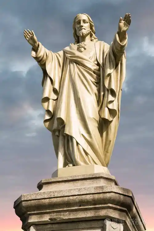 耶稣基督雕像背景是多云的天空和日出