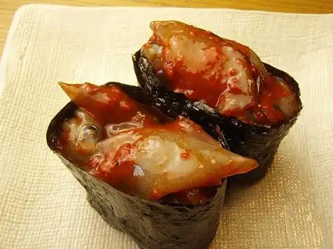 萤火虫鱿鱼泡菜军舰辊. 紫菜和寿司米饭和生鱼片.