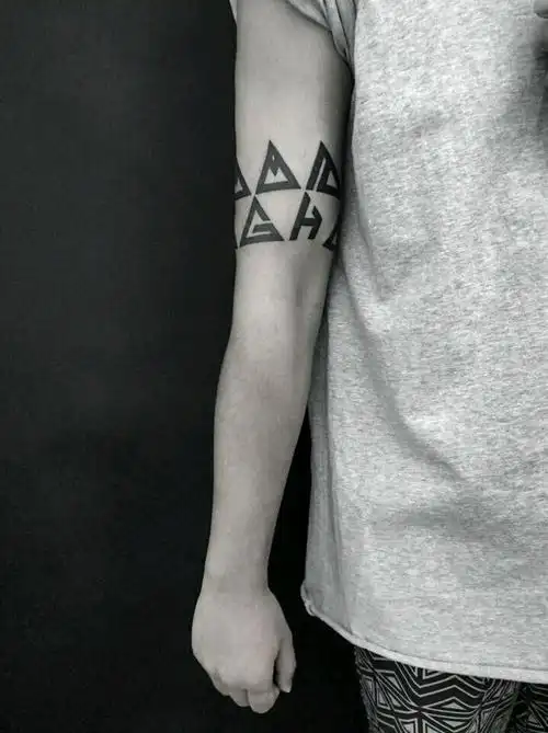 将英文字母转换成三角的几何形状, 然后又结合图腾的风格设计成臂环