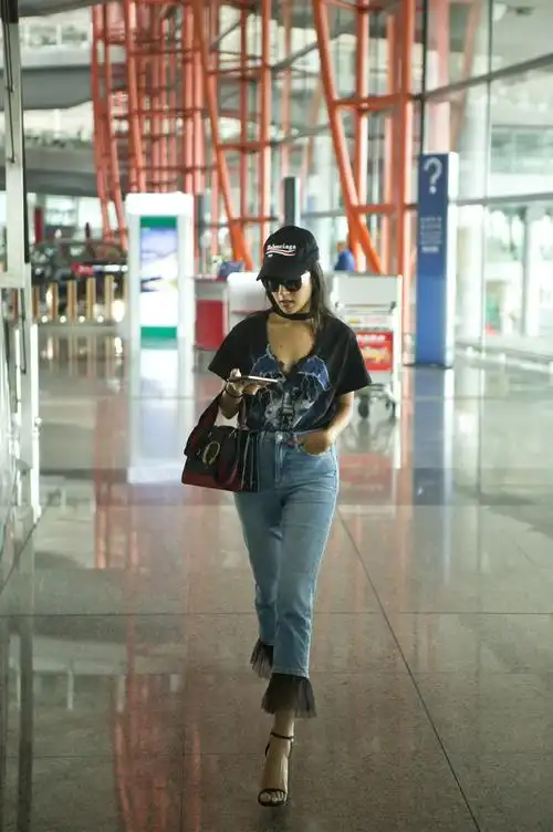吉克隽逸一身清凉潮装打扮现身机场,牛仔裤搭配黑色t恤,脚踩高跟鞋,头