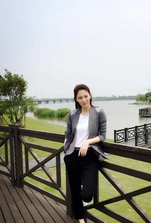 侯梦莎身穿纯白t恤,下半身搭配一条休闲裤,外搭一件灰色外套,脚上穿着