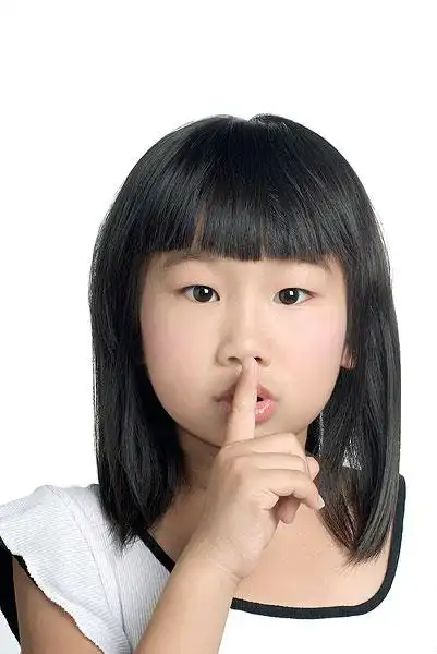 做安静手势的小女孩的特写