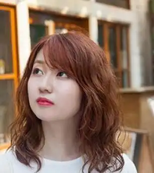 67颇有甜美气质的烫发发型,搭配上简单的斜刘海,修颜显嫩,棕色的
