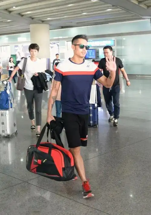 林丹退役后罕见现身机场穿白t反戴棒球帽妻子谢杏芳紧随其后