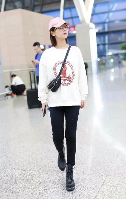 杨紫穿白色卫衣搭配黑色紧身裤现身机场,面带微笑比剪刀手卖萌