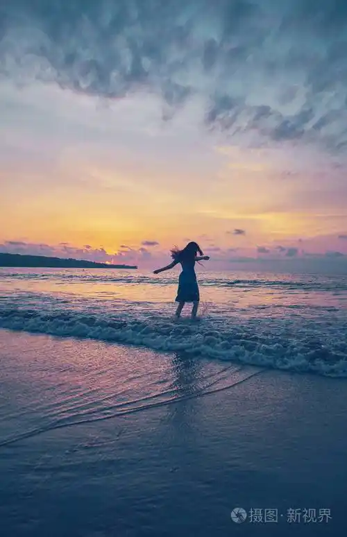日落时海滩上的女孩