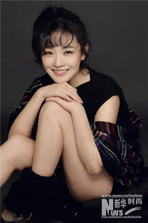 王维维黑色连衣裙搭格子披肩苹果辫展少女感-新华网