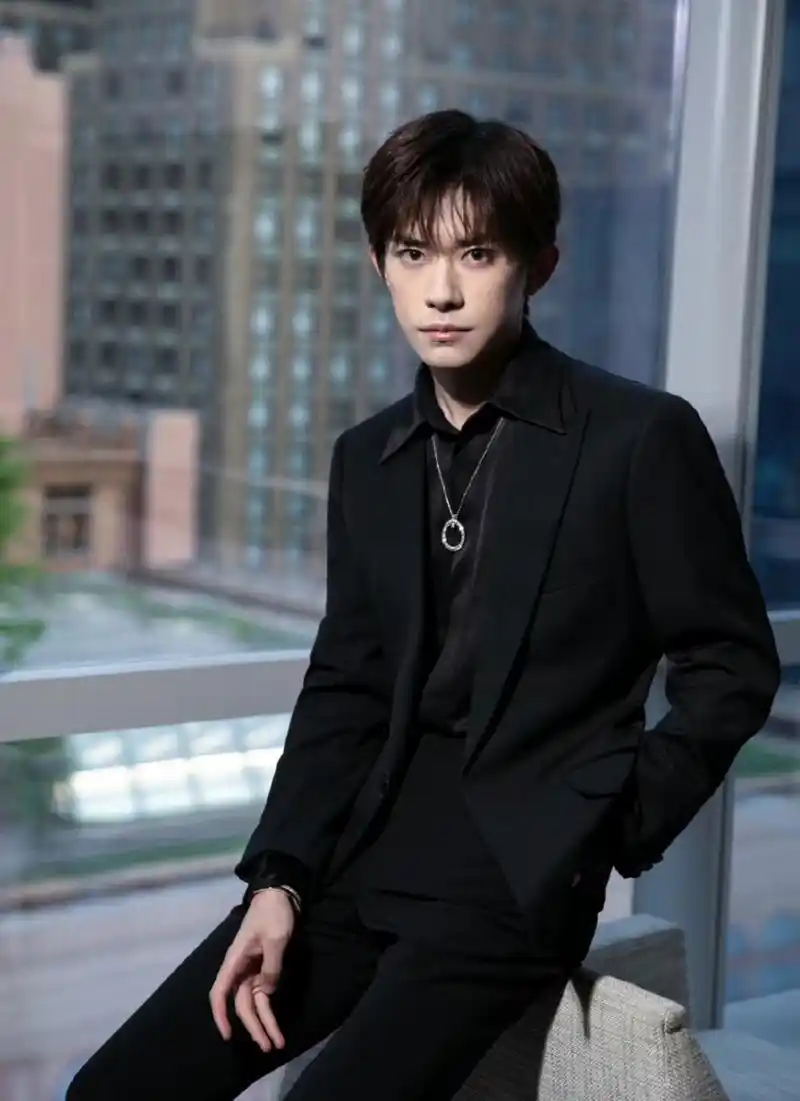 易烊千玺一身黑西装拍大片,脖子上戴的钻石项链彰显贵气.